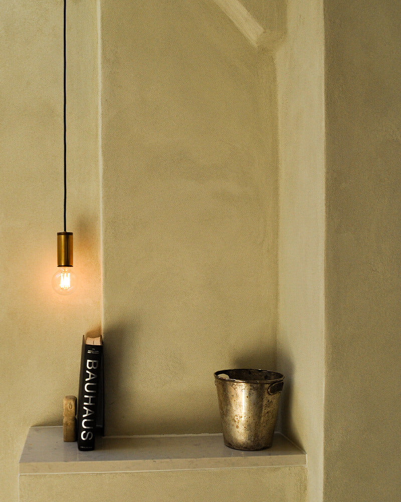 brass pendant bulb light in a corner