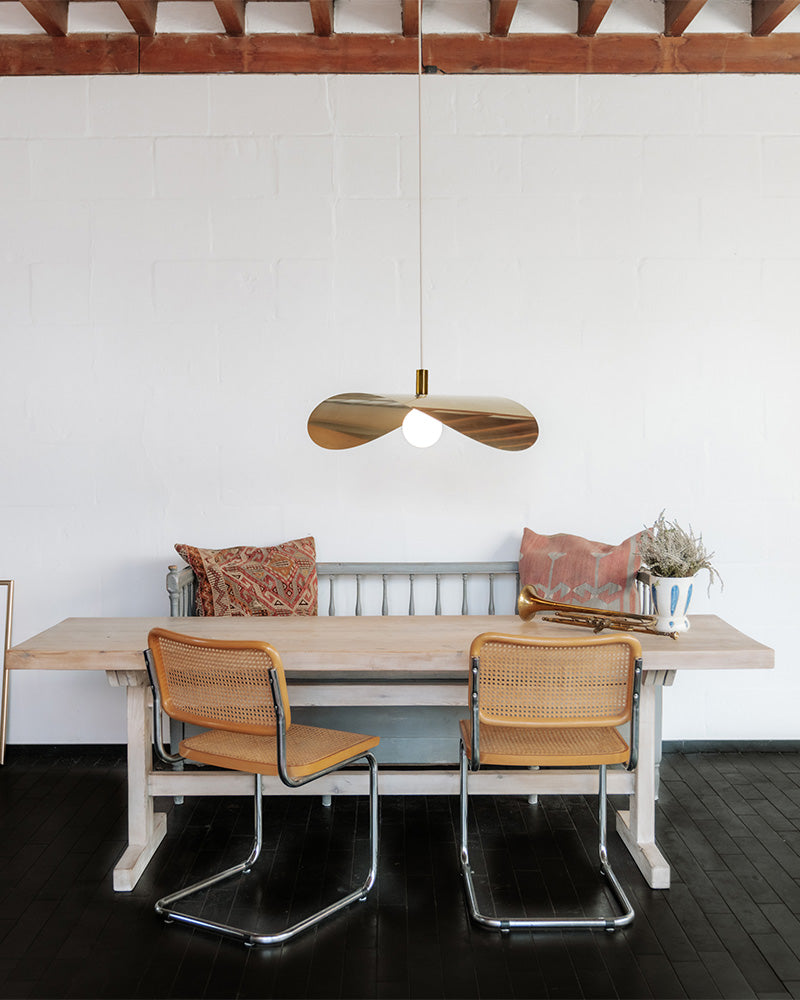 Brass pendant lamp hanging over dining table