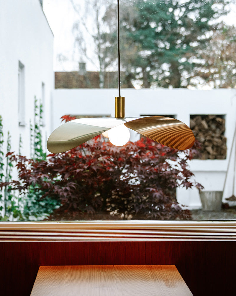 brass pendant light hanging on top of a small cafe table