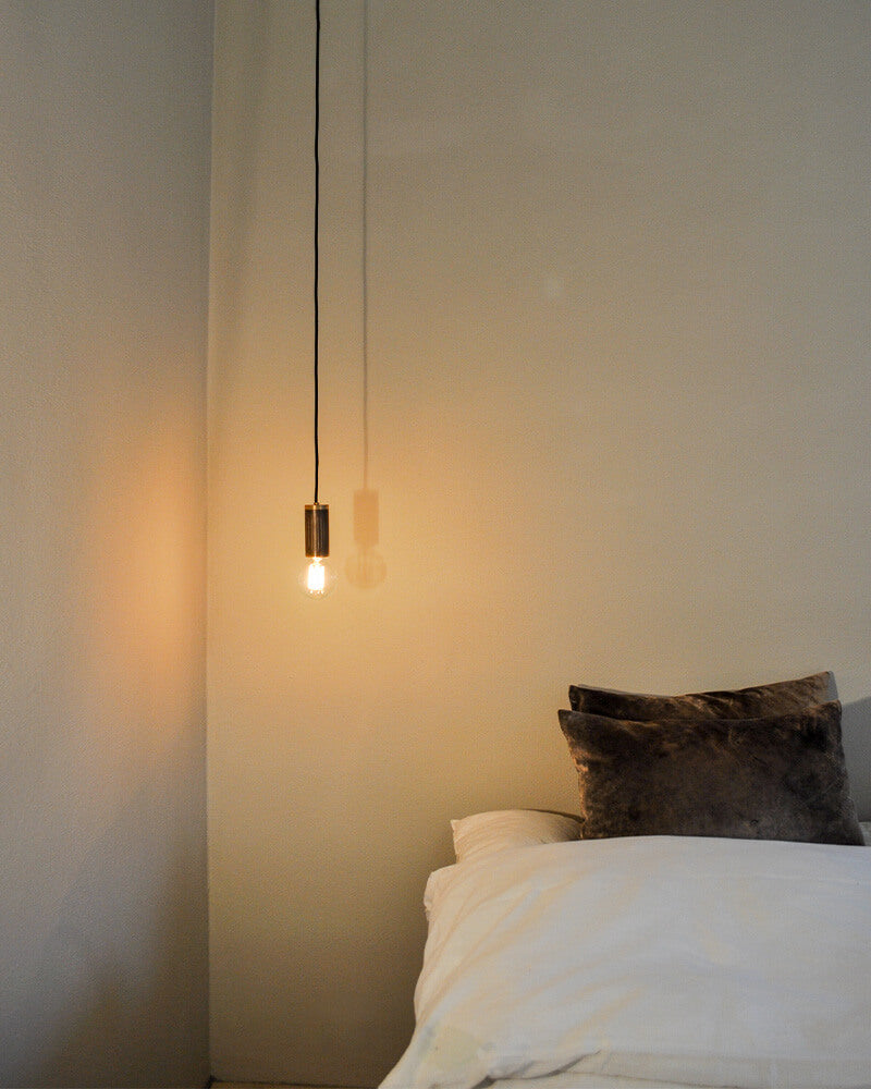 bedside pendant lamp in browned brass and light bulb